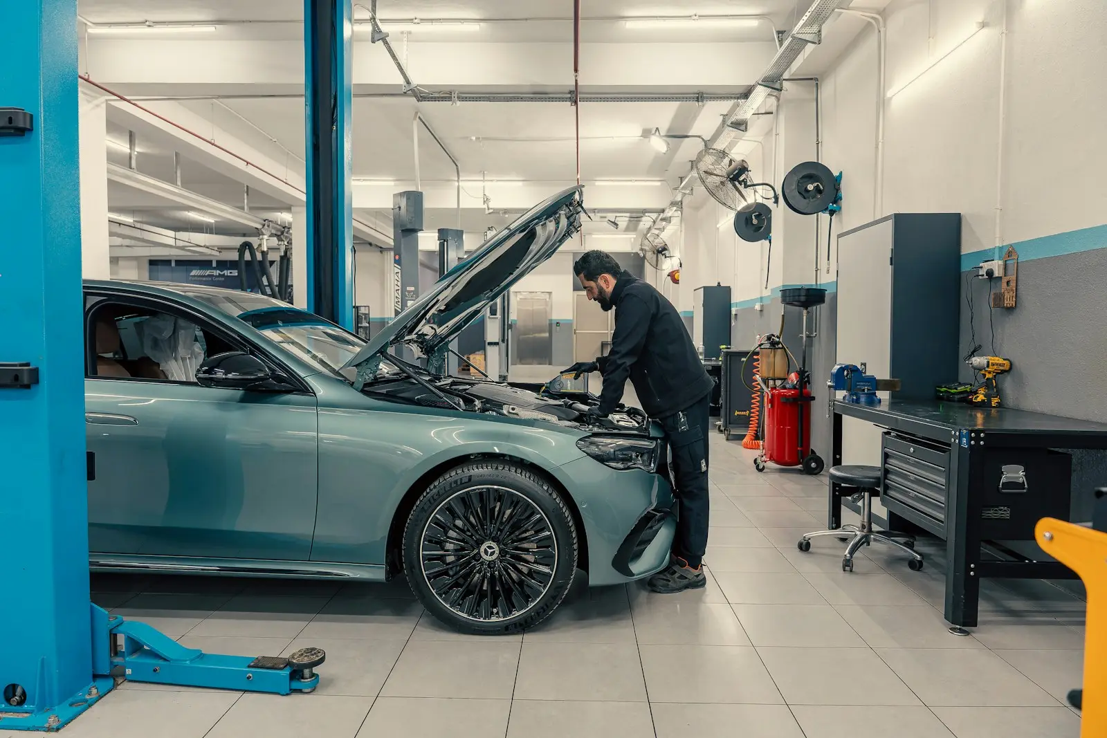 Technician inspecting a Mercedes-Benz E-Class on a lift