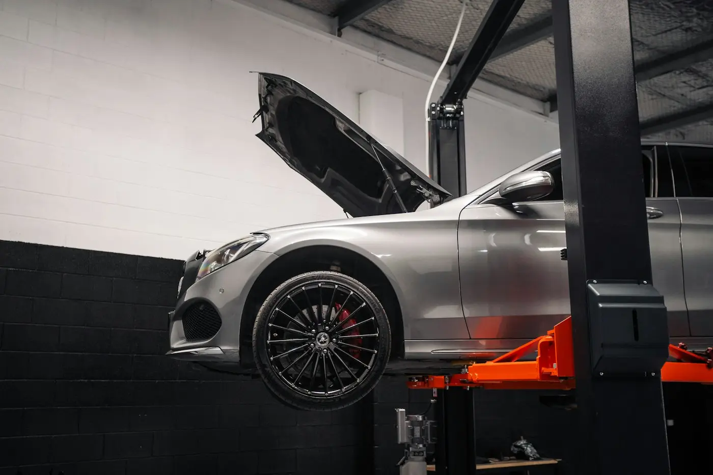 Mercedes-Benz C-Class raised on a lift with the hood open